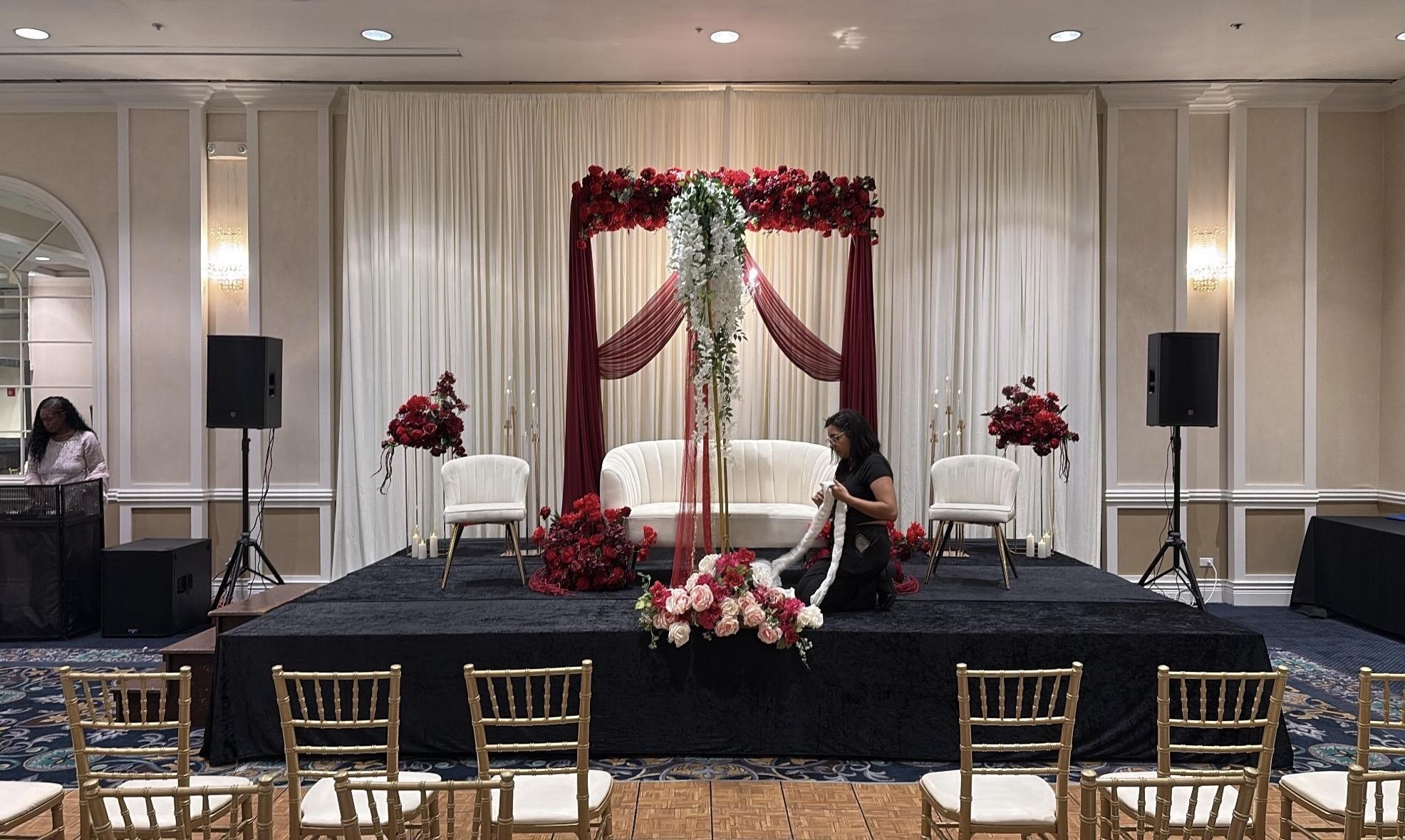 Wedding stage with floral decor and speakers